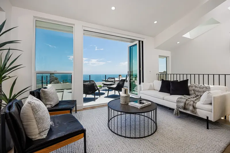 Living room opening to the ocean-view deck — Laguna Beach real estate photography