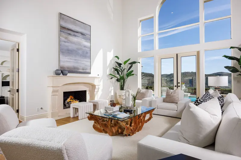 Living room with fireplace and hillside pool view — Newport Coast real estate photography
